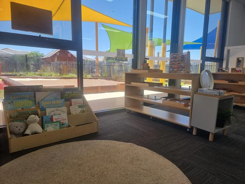 Babies room with low shelves, soft toys and books at infant height