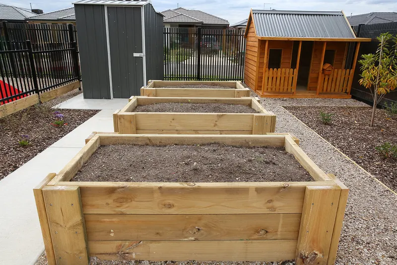 Raised garden beds where children grow vegetables and herbs