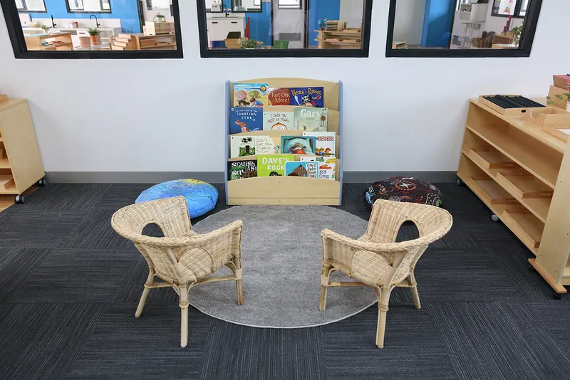 Quiet reading corner with cane chairs and a forward-facing bookshelf