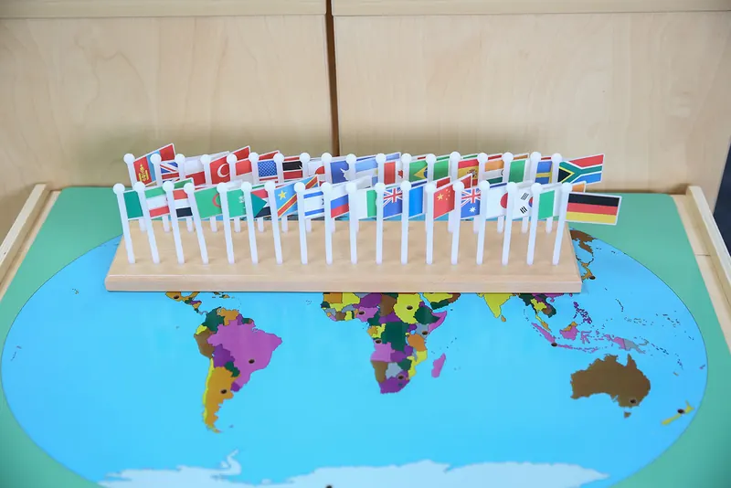 Montessori world puzzle map with a row of national flags